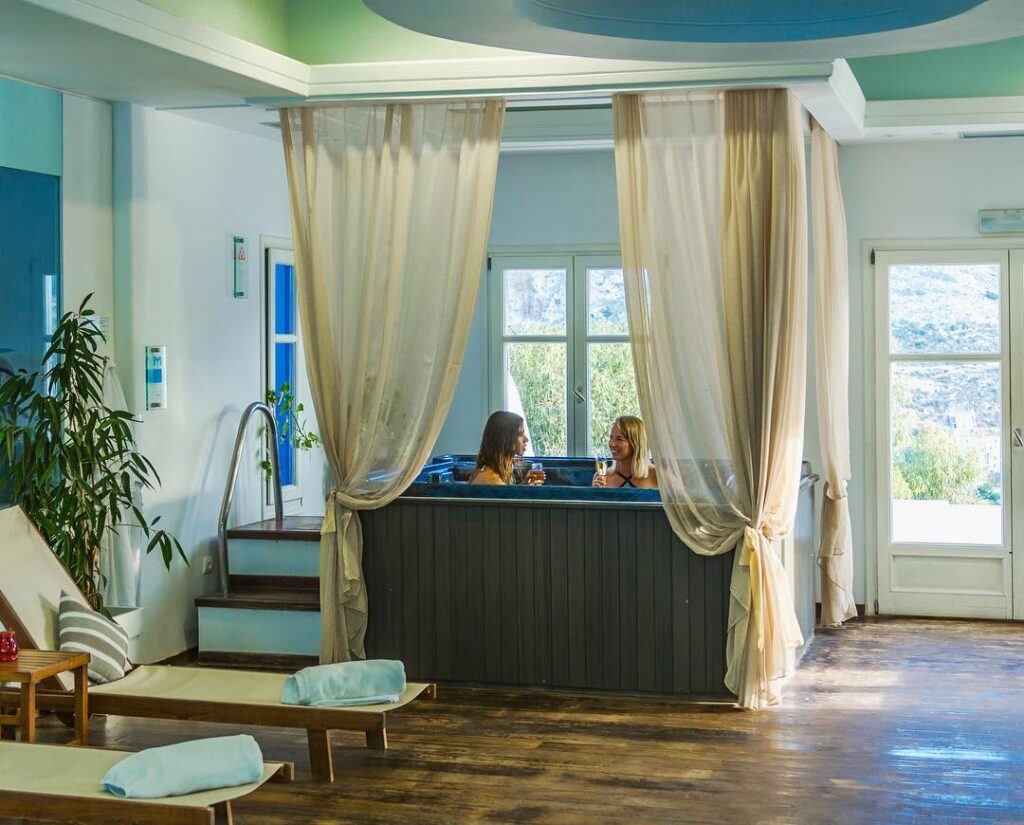 Two women enjoying a relaxing moment in the indoor jacuzzi at Aegialis Hotel & Spa, Greece.