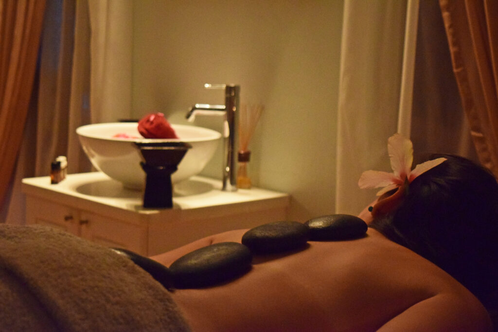 Woman enjoying a relaxing hot stone massage at the spa during Goddess Getaway Retreat in Greece.