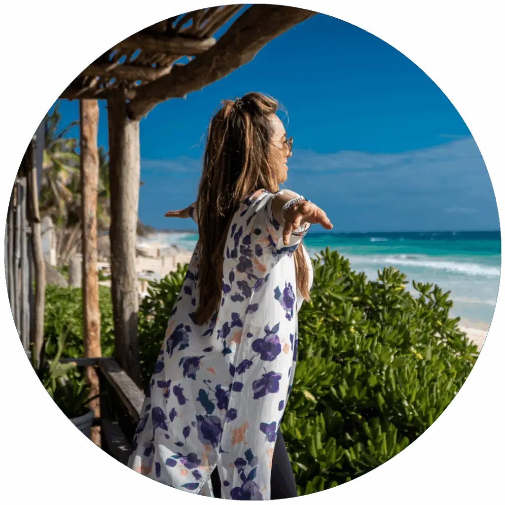 Woman practicing yoga by the ocean in Tulum, Mexico, during a healing retreat.