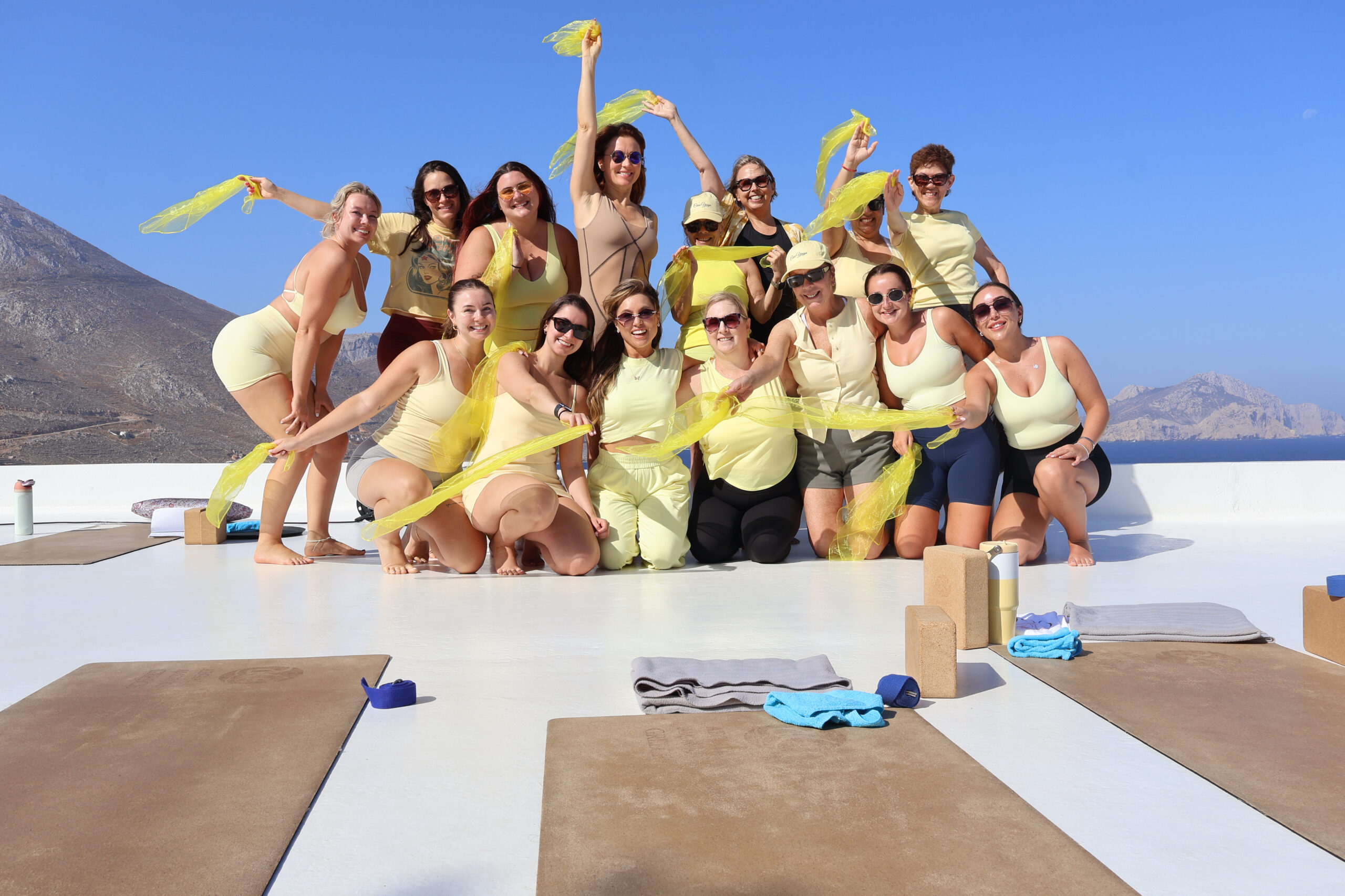 Women celebrating together on a yoga retreat overlooking the sea and mountains in Greece